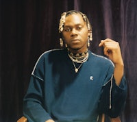 a man in a blue sweater sitting on a chair