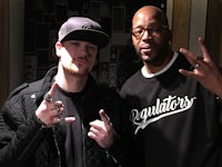 two men posing for a picture in a recording studio